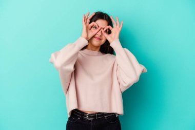 Mavi arka planda izole edilmiş beyaz bir kadın gözlerinde sorun olmadığını gösteriyor.