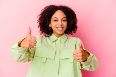 Genç Afro-Amerikan melez kadın tebessüm edip baş parmağını kaldırıyor.