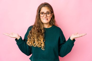 Kafası karışmış genç beyaz bir kadın, bir kopya alanı tutmak için omuz silkiyor..