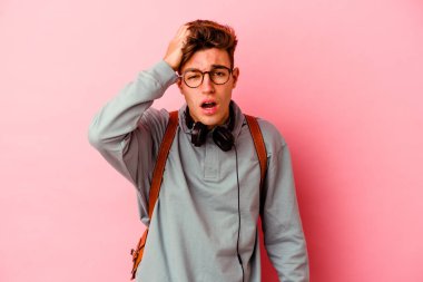 Pembe arka planda izole edilmiş genç bir öğrenci. Çok yorgun ve uykulu..