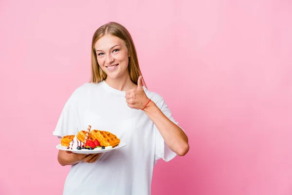 年轻的俄罗斯女人吃着华夫饼 面带微笑 竖起大拇指 — 图库照片