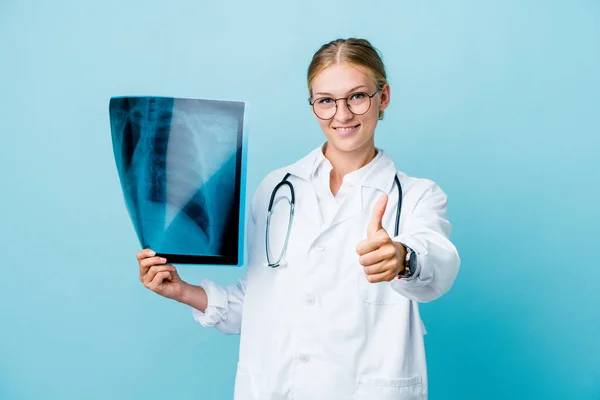 年轻的俄罗斯女医生 拿着蓝色的骨头扫描 竖起大拇指 欢呼雀跃 支持和尊重他人的观念 — 图库照片