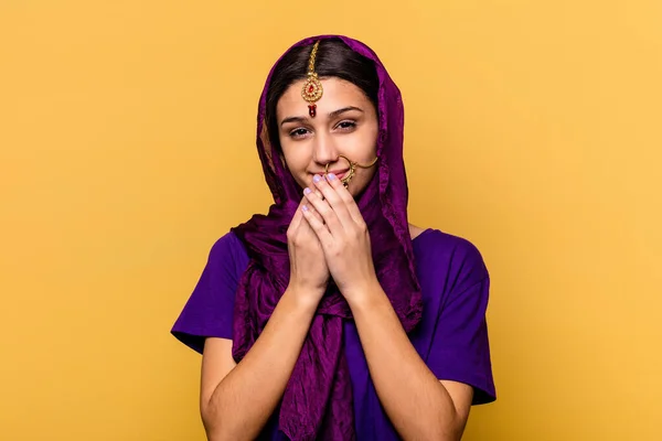 手で口を覆い 何かについて笑って黄色の背景に隔離された伝統的なサリーの服を着て若いインドの女性 — ストック写真
