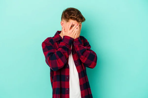 Ung Kaukasisk Man Isolerad Blå Bakgrund Blinka Vid Kameran Genom — Stockfoto