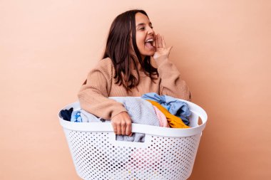 Çamaşırları tutan, bağıran ve ağzı açık olan genç melez bir kadın..