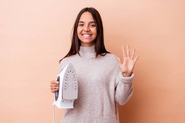 Genç melez bir kadın demir tutuyordu. Beş numarayı parmaklarıyla gülümseyerek gösteriyordu..