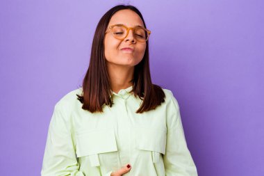 Genç melez kadın karnına dokunuyor, nazikçe gülümsüyor, yemek yiyor ve tatmin oluyor..