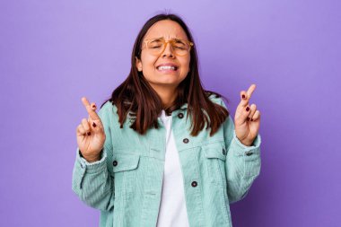 Genç melez kadın şans getirsin diye parmaklarını çaprazladı.