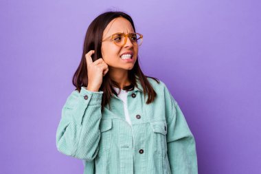 Genç melez kadın elleriyle kulaklarını kapatıyor..