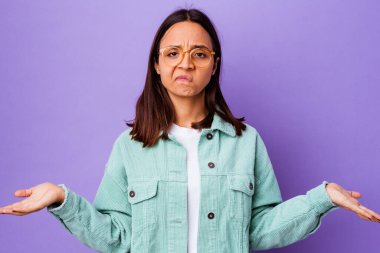 Genç melez kadın kuşkulanarak ve omuz silkerek jestlerini sorguluyor..