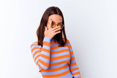 Genç melez kadın kameraya parmaklarıyla göz kırpıyor, yüzünü kapatmaktan utanıyor..