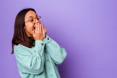 Genç melez kadın bir şeylere gülüyor, elleri ile ağzını kapatıyor..