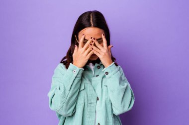 Genç melez kadın kameraya parmaklarıyla göz kırpıyor, yüzünü kapatmaktan utanıyor..