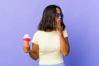 Genç melez bir kadın dondurma yiyor. Esniyor. Ağzı eliyle kapatan yorgun bir jest yapıyor..