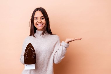 Genç melez bir kadın bir demir tutarak avucunun içinde fotokopi alanı gösteriyor ve belinde bir el daha tutuyor..