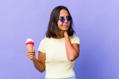 Genç melez kadın dondurma yiyor, kafasının arkasına dokunuyor, düşünüyor ve bir seçim yapıyor..