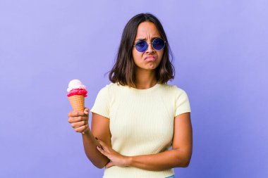 Melez bir kadın dondurma yiyor hoşnutsuzca kaşlarını çatıyor, kollarını kavuşturuyor..