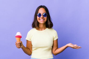 Genç melez kadın dondurma yiyor ve hoş bir yüz ifadesi sergiliyor..