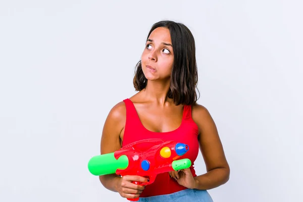 Mujer Joven Raza Mixta Sosteniendo Una Pistola Agua Aislada Confundida —  Fotos de Stock