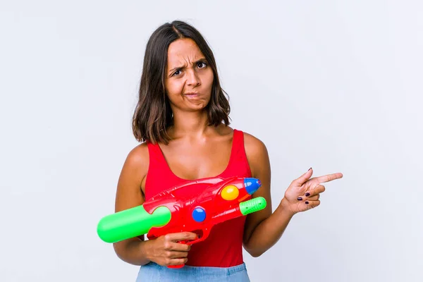 Jonge Gemengde Ras Vrouw Met Een Waterpistool Geïsoleerd Geschokt Wijzend — Stockfoto
