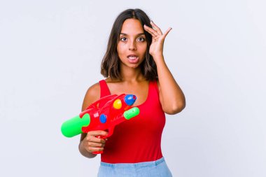 Su tabancası tutan genç melez kadın yüksek sesle bağırıyor, gözleri açık ve elleri gergin tutuyor..