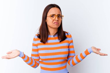 Genç melez kadın kuşkulanarak ve omuz silkerek jestlerini sorguluyor..