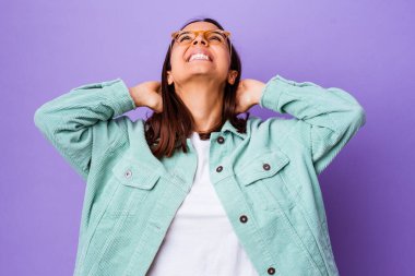 Genç melez kadın kendini soyutlamış, kendinden emin, elleri başının arkasında..