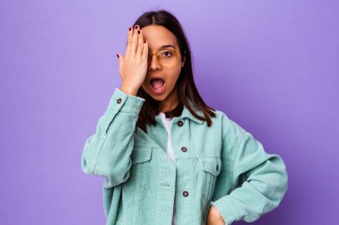 Genç melez kadın izole edilmiş, yüzünün yarısını avuç içiyle kaplayarak eğleniyor..