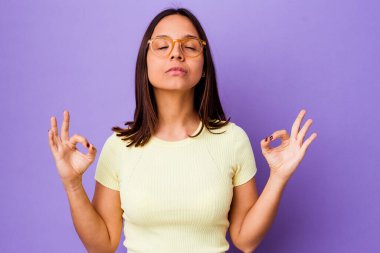 Genç melez kadın yoğun çalışma gününden sonra dinleniyor, yoga yapıyor..