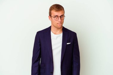 Beyaz arka planda soyutlanmış, kafası karışmış, şüpheci ve kararsız genç beyaz bir adam..