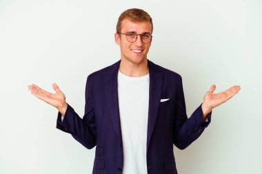 Beyaz arka planda izole genç beyaz iş adamı kollarıyla ölçek yapar, mutlu ve kendinden emin hisseder..