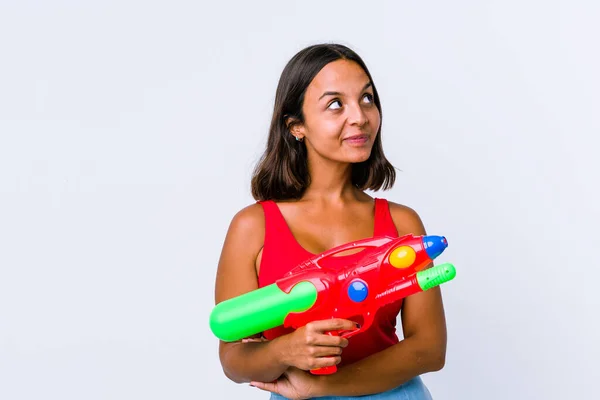 Joven Mujer Raza Mixta Sosteniendo Una Pistola Agua Aislada Soñando —  Fotos de Stock