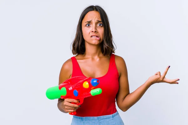 Joven Mujer Raza Mixta Sosteniendo Una Pistola Agua Aislada Confundida —  Fotos de Stock