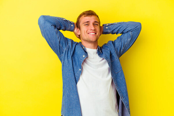 Young caucasian man isolated on yellow background stretching arms, relaxed position.