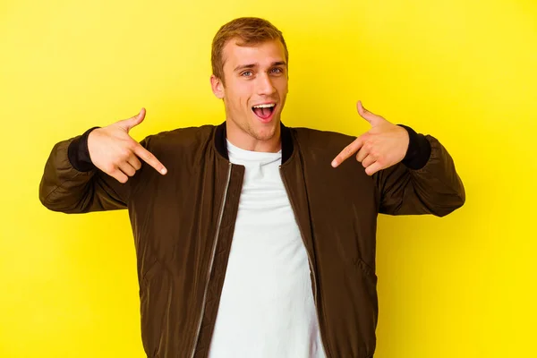 Jovem Caucasiano Isolado Fundo Amarelo Surpreendido Apontando Com Dedo Sorrindo — Fotografia de Stock