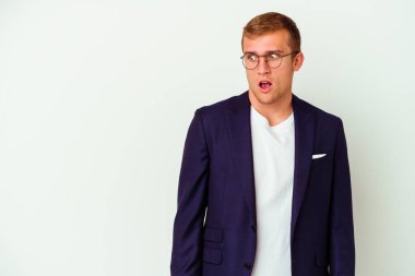 Beyaz arka planda soyutlanmış genç beyaz bir adam gördüğü bir şey yüzünden şoka uğruyor..