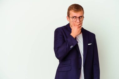 Beyaz arka planda izole edilmiş genç beyaz bir adam. Düşünceli bir şekilde bir fotokopi odasına bakıyor. Ağzını eliyle kapatıyor..