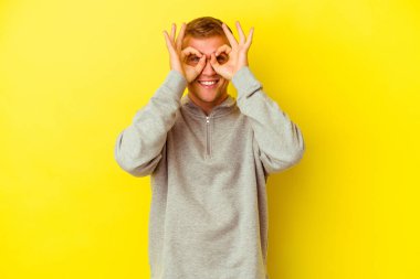 Kafkasyalı genç adam sarı arka planda izole edilmiş. Heyecanlı..