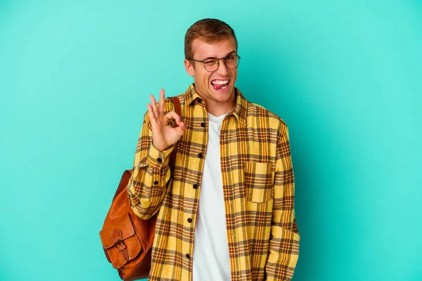 Junger Kaukasischer Student Isoliert Auf Blauem Hintergrund Zwinkert Mit Einem — Stockfoto