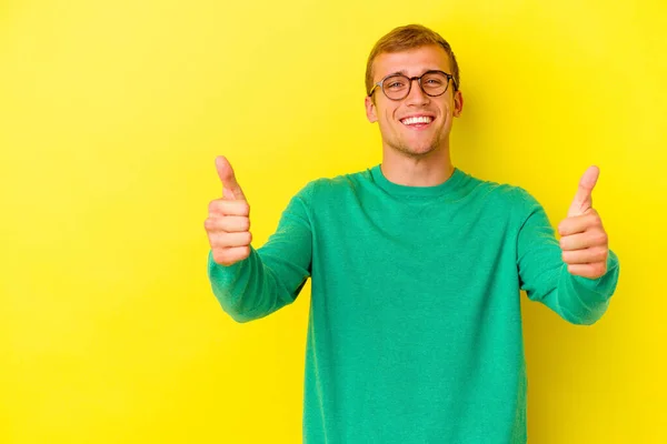 Νεαρός Καυκάσιος Άνδρας Απομονωμένος Κίτρινο Φόντο Χαμογελώντας Και Υψώνοντας Τον — Φωτογραφία Αρχείου