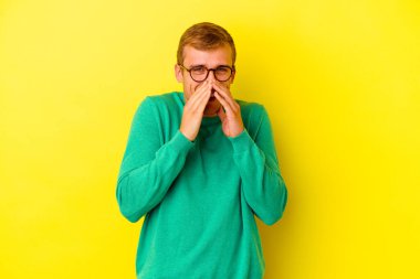 Sarı arka planda izole edilmiş genç beyaz bir adam bir dedikodu söylüyor, bir haber sunuyor..