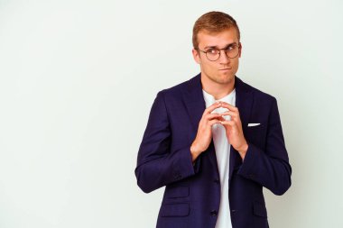 Kafkasyalı genç bir adam beyaz arka planda izole edilmiş bir plan kuruyor, bir fikir kuruyor..