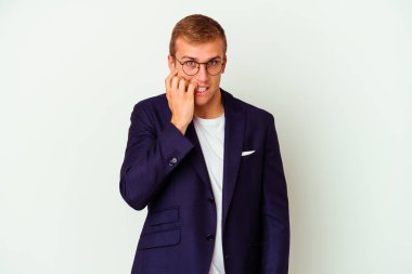 Beyaz arka planda izole edilmiş, tırnak yiyen, gergin ve endişeli genç bir beyaz iş adamı..