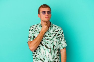 Mavi arka planda izole edilmiş yaz kıyafetleri giyen beyaz bir adam virüs veya enfeksiyon yüzünden boğazında ağrı hissediyor..