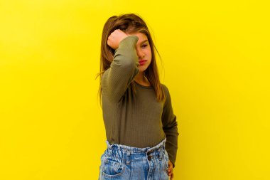 Sarı arka planda izole edilmiş küçük beyaz kız zaferi, tutkuyu ve coşkuyu kutluyor, mutlu bir ifade..