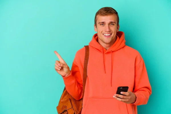 Jovem Estudante Caucasiano Segurando Telefone Celular Isolado Fundo Azul Sorrindo — Fotografia de Stock