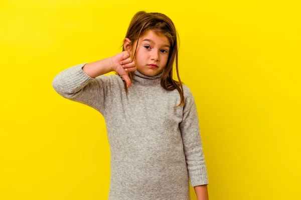 親指を下に示す黄色の背景に隔離された小さな白人の女の子 失望の概念 — ストック写真