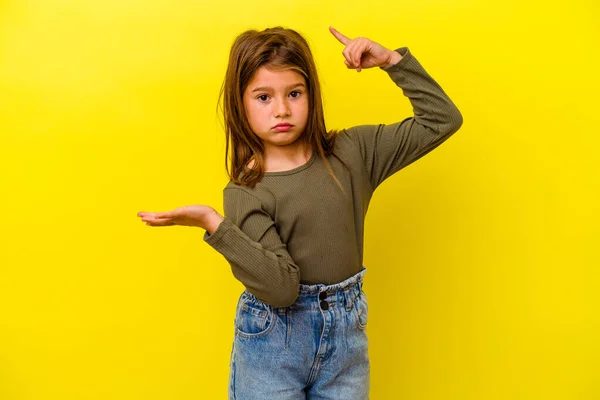 Μικρό Καυκάσιο Κορίτσι Απομονωμένο Κίτρινο Φόντο Κρατώντας Και Δείχνοντας Ένα — Φωτογραφία Αρχείου