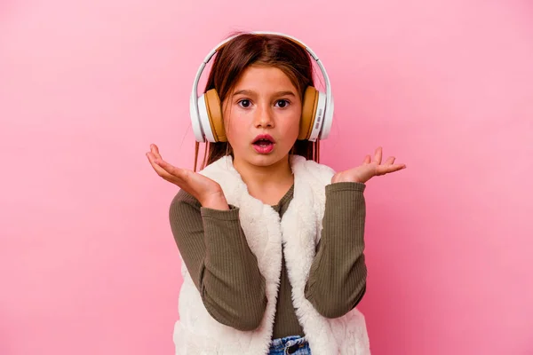 Klein Blank Meisje Luisteren Muziek Geïsoleerd Roze Achtergrond Verrast Geschokt — Stockfoto