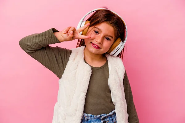 Маленькая Кавказская Девочка Слушает Музыку Розовом Фоне Показывая Номер Два — стоковое фото